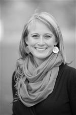 Photo of Kate Gammill from the shoulders up wearing a scarf and round earrings.